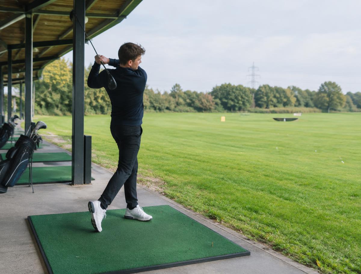 Golfer oefent op de overdekte driving range